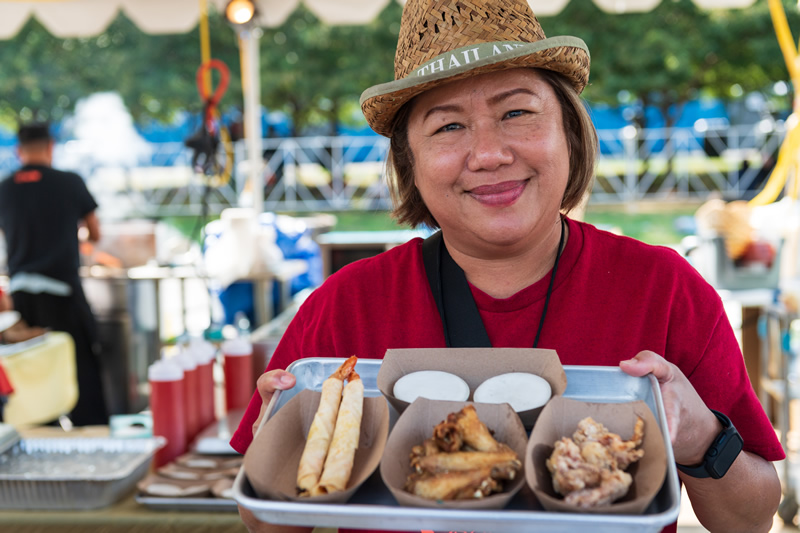 Food vendor holding up a variety of food